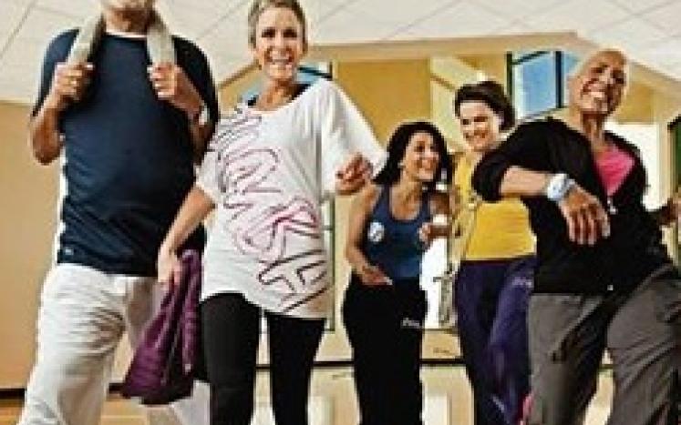 Group of adults smiling about a fitness class they are about to start or just concluded